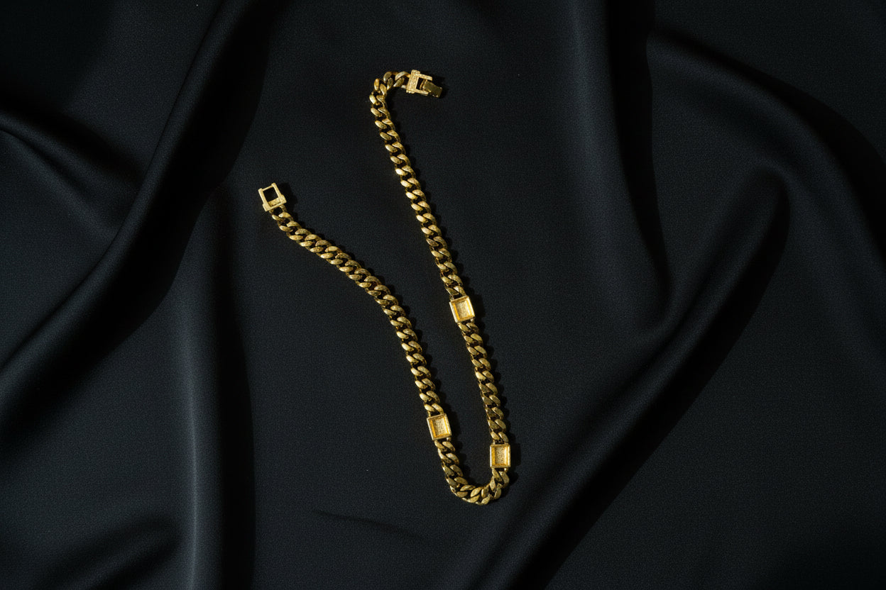 The back of the Swarovski Gold Curb Chain Necklace with Crystal & Black Enamel Accents on a black fabric background.
