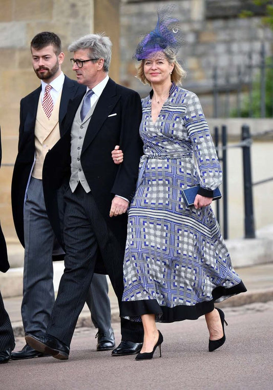 Man and woman walking outdoors. The woman is wearing Amanda Wakeley Silk Wrap Dress geometric print in shades of blue.