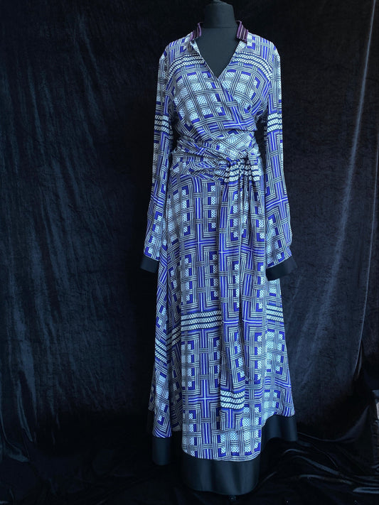 Amanda Wakeley Silk Wrap Dress. Geometric print in shades of blue, on a mannequin against a black background.