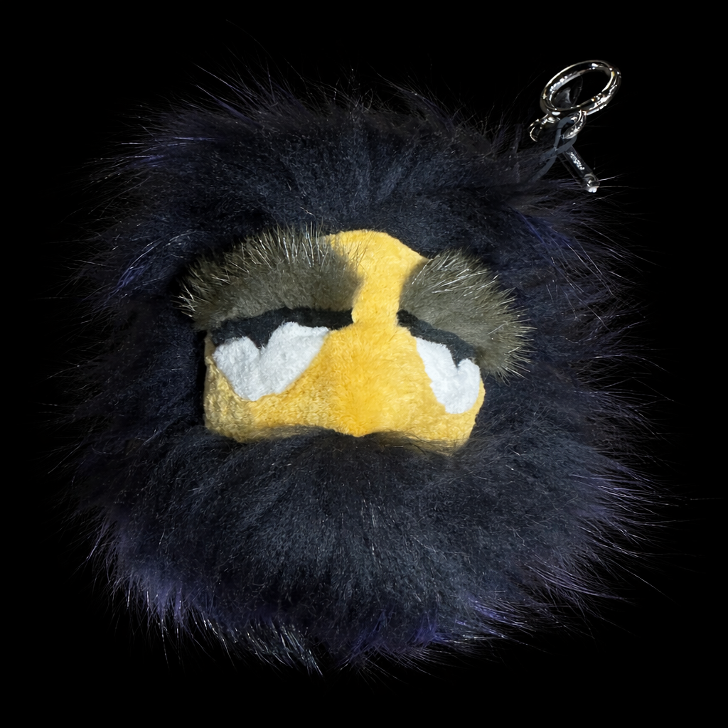 Fendi Furry keychain with a yellow face and black fur on a black background