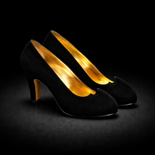 Salvatore Ferragamo Creations Limited Edition Pumps black suede with a gold leather interior on a black background.