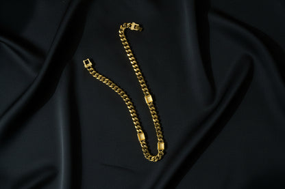 The back of the Swarovski Gold Curb Chain Necklace with Crystal & Black Enamel Accents on a black fabric background.