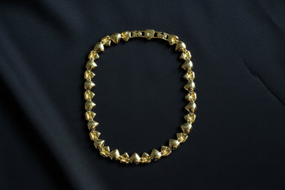 The back of this Swarovski Crystal Heart Necklace in Gold Tone on a black fabric background.