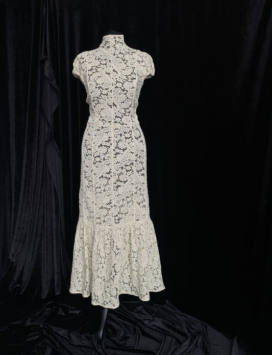 Victoria Beckham Lace Midi Dress in Ivory on a mannequin against a black background.