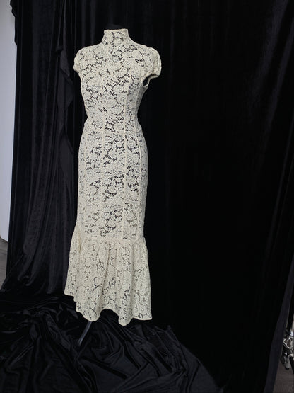 Victoria Beckham Lace Midi Dress in Ivory on a mannequin against a black background.