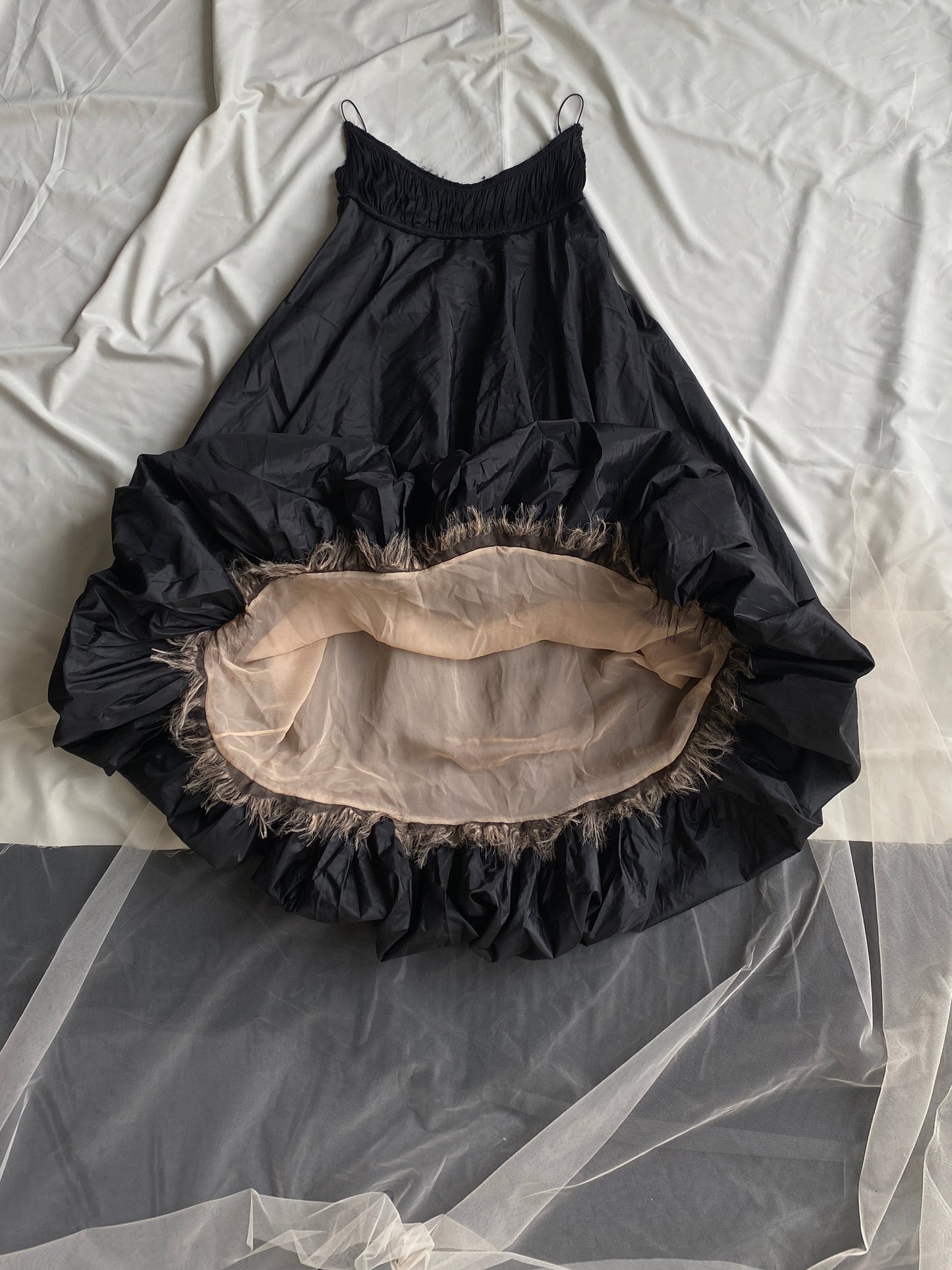 Isabel Toledo Sculptural Taffeta Dress. Black exterior, showing a beige interior displayed on a white fabric background.