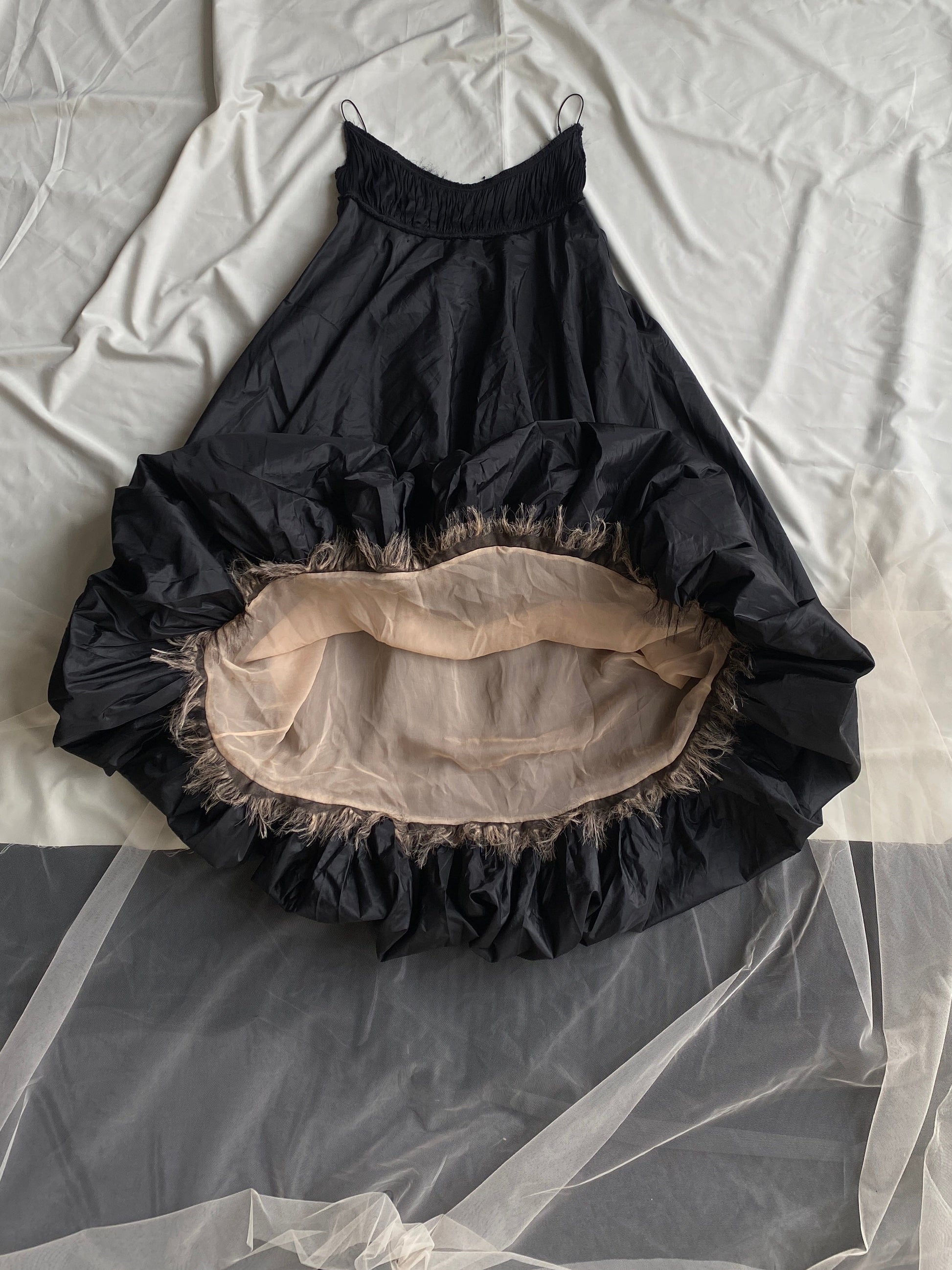 Isabel Toledo Sculptural Taffeta Dress. Black exterior, showing a beige interior displayed on a white fabric background.