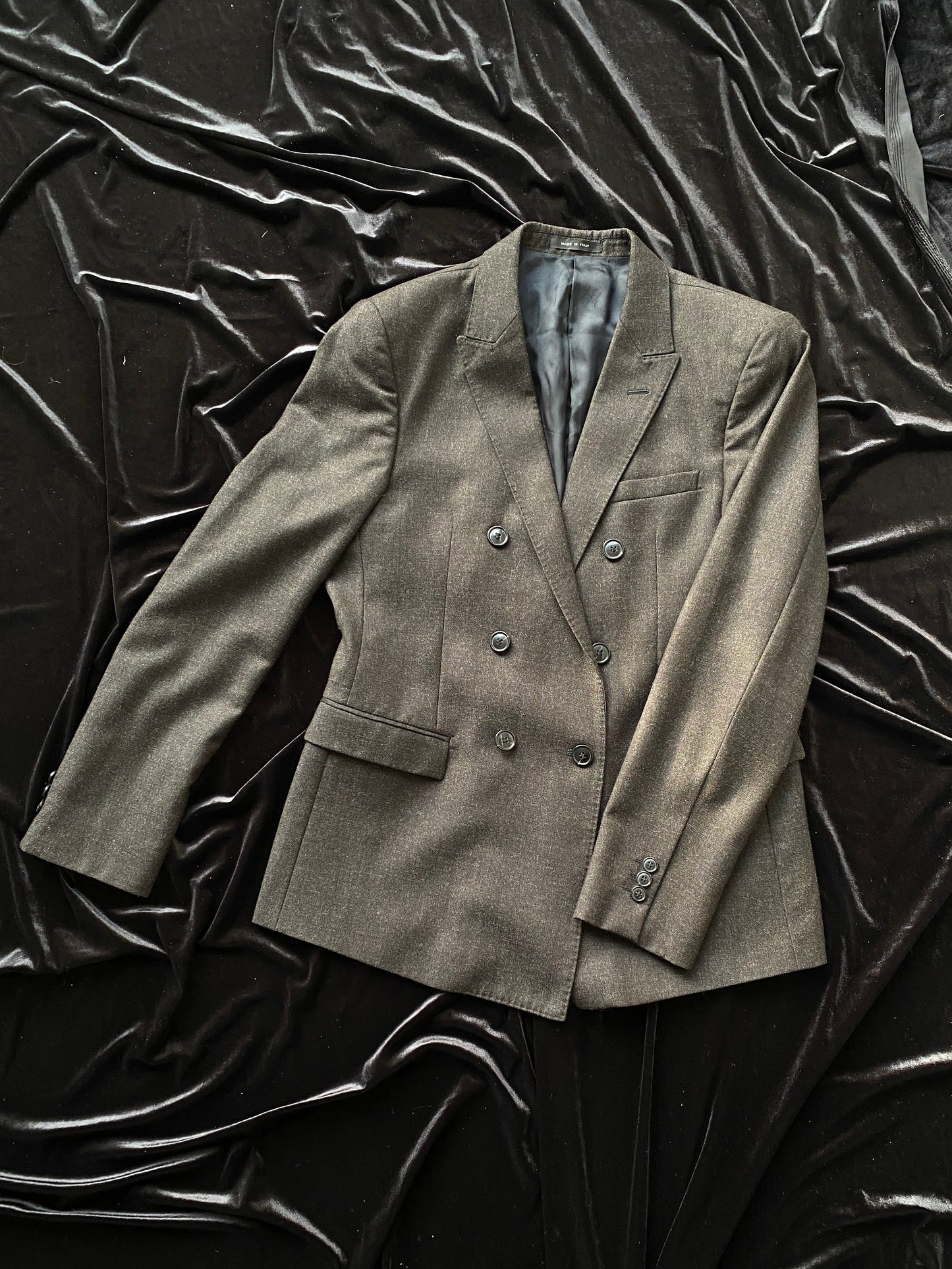 A gray Giorgio Armani Double-Breasted Jacket, lying on a black background.