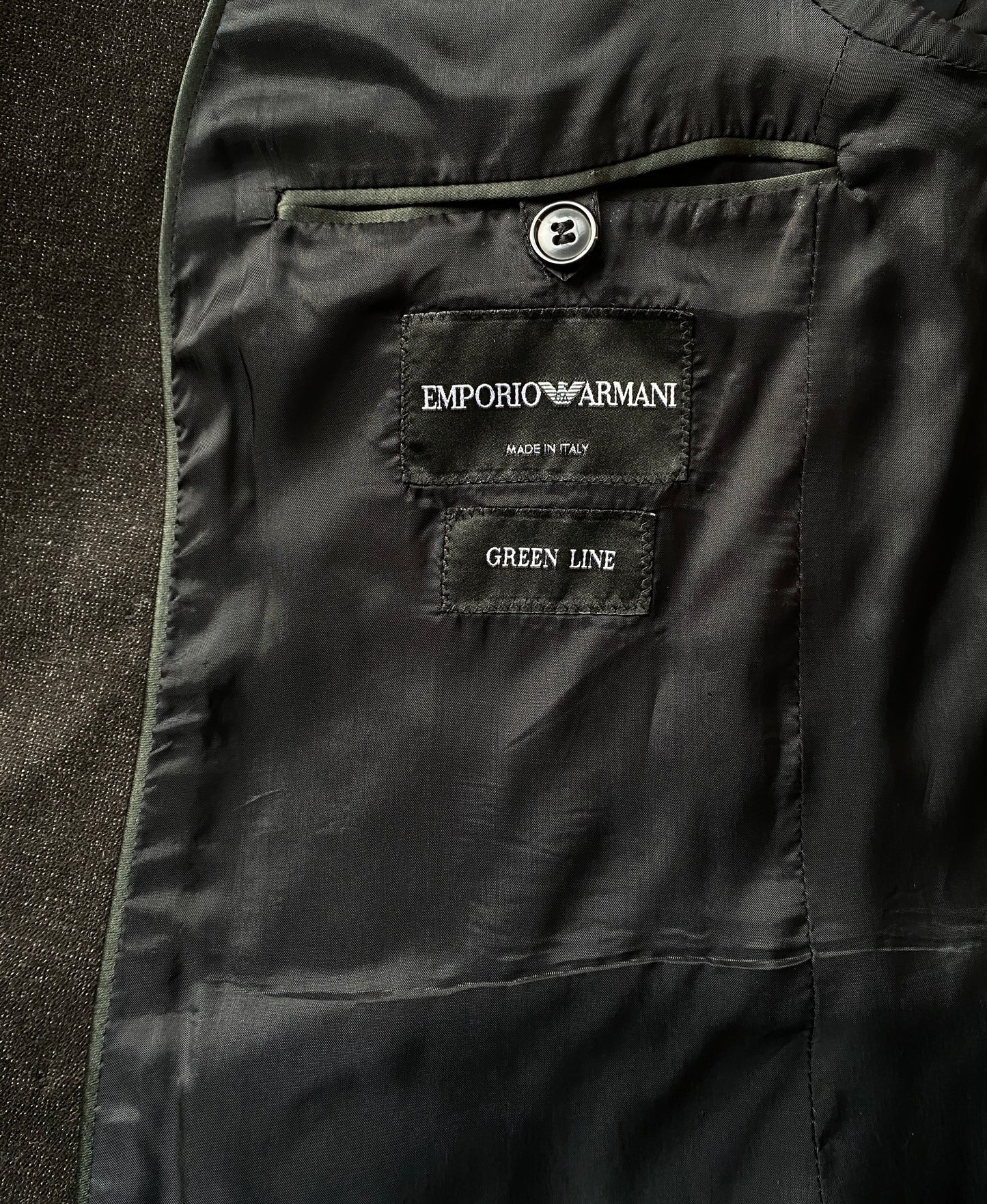 Inside label of a gray Giorgio Armani Double-Breasted Jacket. The label reads: Emporio Armani. Made In Italy. Green Line.
