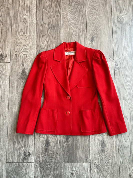 Vibrant red Yves Saint Laurent Rive Gauche Variation Jacket laid on a wooden floor.