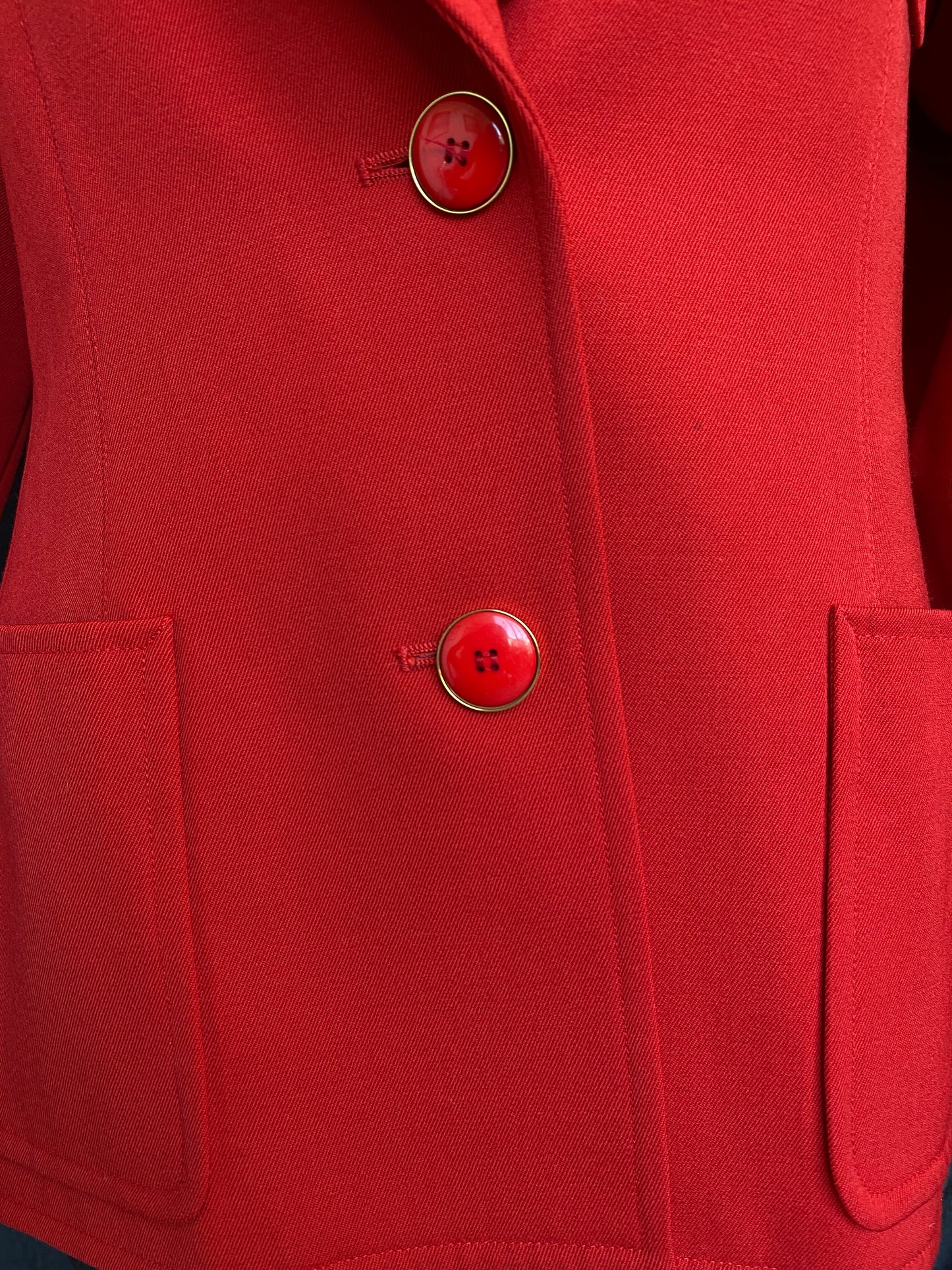 Close-up of the front two buttons fastened, on the vibrant red Yves Saint Laurent Rive Gauche Variation Jacket.