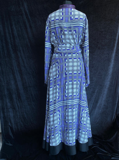 The view of the back of an Amanda Wakeley Silk Wrap Dress. Geometric print in shades of blue on a mannequin against a black background.