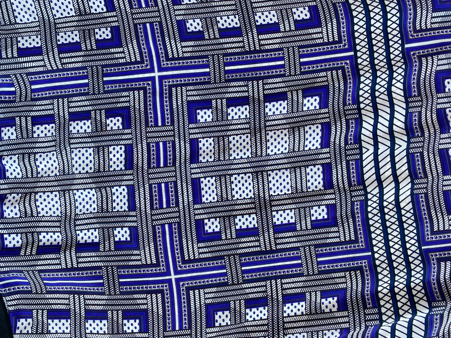 A close up of the geometric print in shades of blue, on the Amanda Wakeley Silk Wrap Dress.