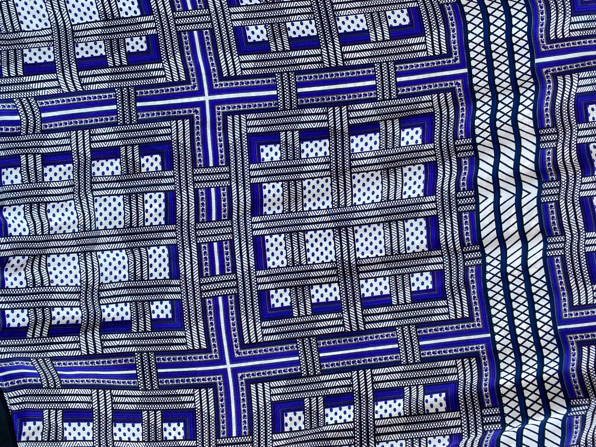 A close up of the geometric print in shades of blue, on the Amanda Wakeley Silk Wrap Dress.