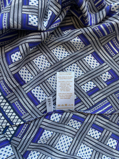 A close up image of the labels inside the Amanda Wakeley Silk Wrap Dress. Geometric print in shades of blue. 