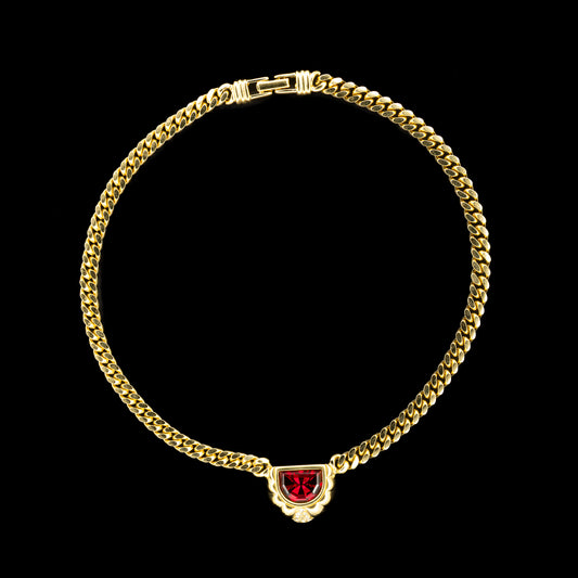 Swarovski Gold Chain Necklace with Ruby Red Crystal Pendant on a black background.