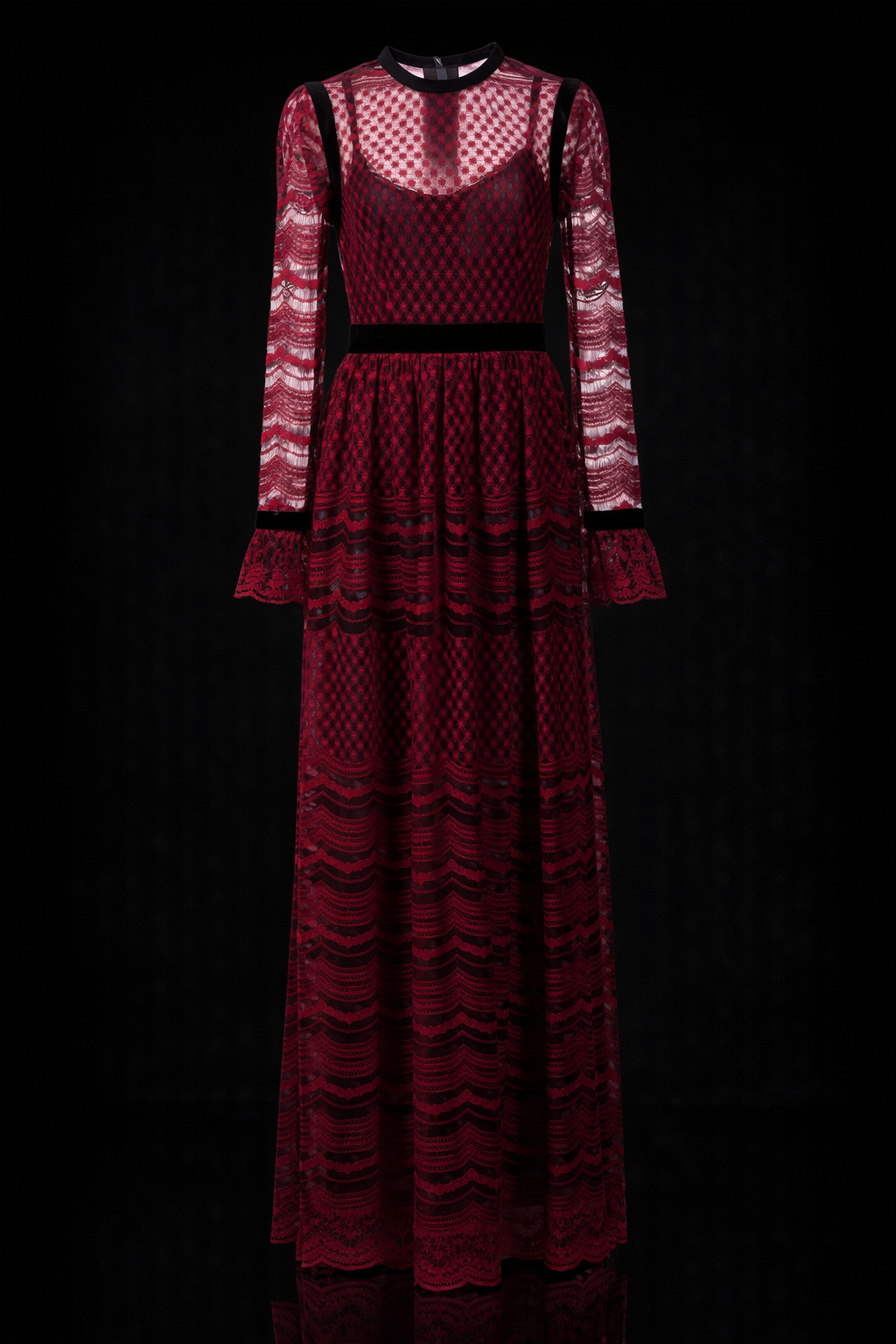 Woman modelling a Philosophy di Lorenzo Seraphini burgundy long sleeve gown dress against a black background.