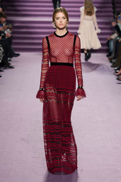 Model wearing Philosophy di Lorenzo Seraphini burgundy long sleeve gown dress on a runway. 