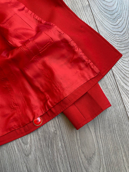 Close up view of the inside lining of the vibrant red Yves Saint Laurent Rive Gauche Variation Jacket, laid on a wooden floor.